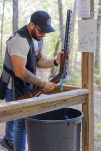 Male guest discarding shells after breaking clays on Etowah Valley Sporting Clays's Blue Course.